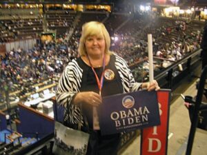Connie Wilson inside the Pepsi center holding an Obama/Biden sign.